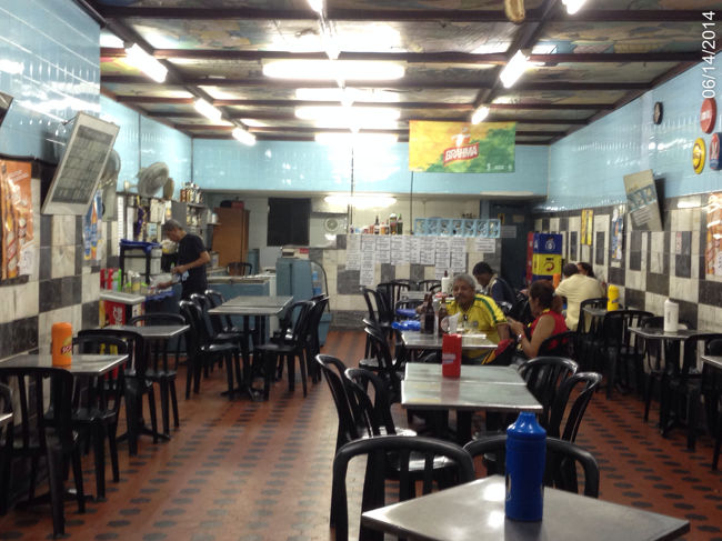 旧市街の安食堂。さっきジュースのみながらブラジル人のおっさんたちとＴＶ観戦したところ。再び同じ場所で少し早い夕食を食べながらコスタリカーウルグアイ戦を観戦。食事はスパゲティだったがやはりふにゃふにゃ。イタリア以外のパスタはなんでこんなにふにゃふにゃなんだろう。でもスタジアムには多分ろくな食い物ないだろうし我慢して腹に詰める。コスタリカがウルグアイから点を取るたびにブラジル人のおっさん達は大喜びしていた。マラカナンの恨みはいまでも健在なのだろうか。