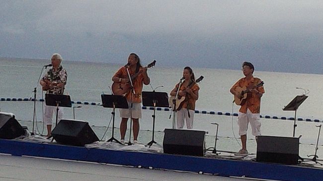 出番も終わり友達が1人別行動になるため再度<br />駐車場へ戻る。<br /><br />友達を見送りまたホテルへ。<br />何度往復するのだろう(苦笑)<br /><br />夕方6時半からはビーチでステージが始まる。<br />先生も出るので見てから帰ろうと。<br /><br />始まる前に雨が降ってきた。<br />まさかのステージ中止か・・・<br />でもそこはALOHA POWER♪<br />直前にやんでステージ開始！<br /><br />夕暮れの海をバックにTony先生のバンド<br />レオアロハの生歌♪<br />このステージには出演者が10人いないと<br />でれない。<br />いつかここで踊りたいね〜と話した。<br /><br />しかしこの時点でホテル滞在時間が12時間！<br />さすがに疲労もピーク・・・<br />先生の出演時間を確認したら9時半だって・・<br />これは無理だと先生にごめんなさいして<br />帰ることに。<br />