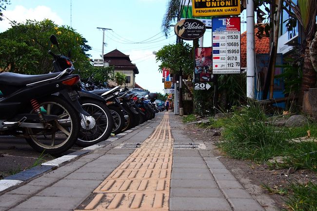 ウブドメイン通りをウブド市場方面へ。<br />歩道の脇にはズラっと原付が停められていて、バイク社会のバリ島ではこの様子がひたすら続く。