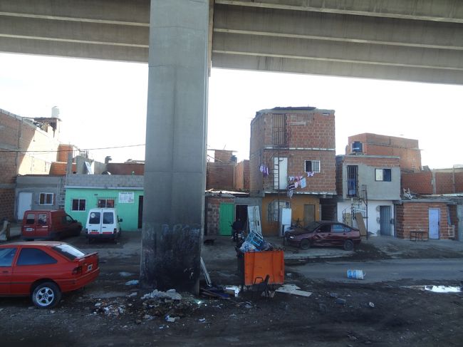 ボカ港沿いを走っているときのバスの車内から。<br /><br />四角い小屋が積みあがっていますが、これは家。<br />ここで暮らしている人もいるそうです。<br /><br />ガイドさんから、アルゼンチンは貧富の差が激しい国であると紹介がありました。<br />但し、肥沃な国土を有し、世界一の穀物自給率を誇ることから、食べ物には困らないので暴動は起きない、とのこと。<br />本当にそんな理由なの!?