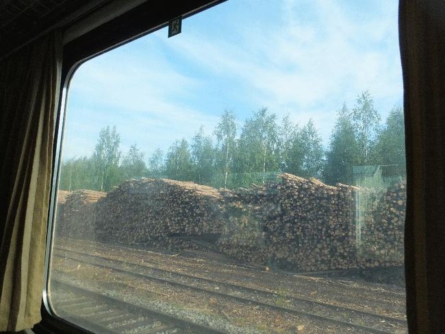 　7時34分発のセイナヨキ行は、2両編成のディーゼルカーであった（旅情の点では客車を期待していたのだが）。ヌルメスやサヴォンリンナ行で乗車したのと同じ形式であるが、中に入ってみると、どうやら空調が聞いているようであった（これまでのは非冷房であった）。ぱっと見は同じでも、色々と差があるようである。<br />　同駅を定刻に出発。沿線に人工物はほとんどなく、ひたすら森林、時々湖、である。景色自体は美しいが、いかんせん窓が薄汚れているため、写真を撮ることは難しい。<br />　思い出したかのように駅に停まるが、周辺には幹線のような大きな集落はなく、駅構内も木材の山があるだけである。<br /><br />＠田舎駅
