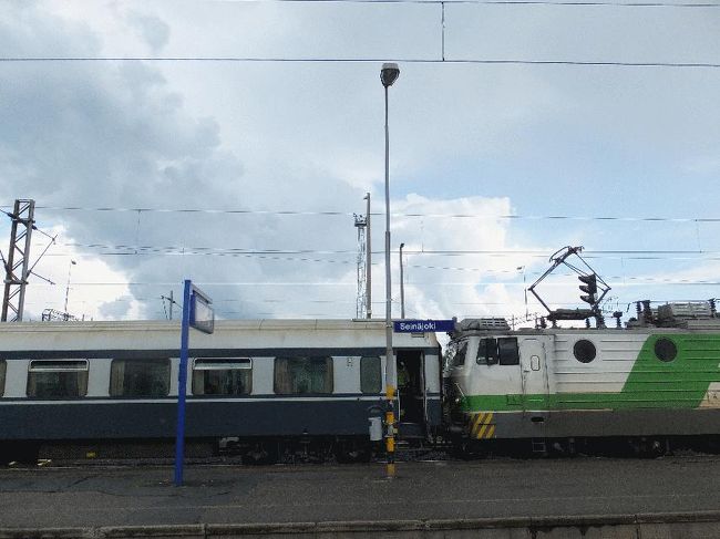 　先ほどまでは上記の写真のように晴れていたが、セイナヨキで乗り継ぎ列車を待っていると、急に雨が降り出し、遠くでは雷も鳴り始めた（しかし結果論からすると、今回のフィンランド行では、列車に乗車中や乗り換えの際には雨に降られたものの、散策時はほとんど快晴であり傘は一度も使用しなかった。また雨が降ったのも、ほんの数回、それも数分程度であった）。<br />　入線してきたヘルシンキ行のICは、これまでで最長の12両編成であった（基本編成は6両であり、それが2編成繋がっている。なお、地域によっては5両以下のICもあるようであった）。最前部にあったエキストラに乗り込む。<br /><br />＠遠くに雷雲が（手前の車両はヴァーサから乗ってきたもの）