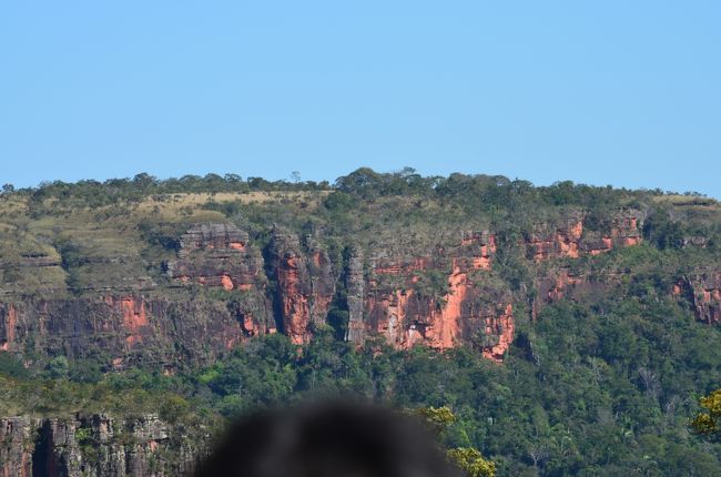 トレッキングコースを進んで行くと、眼前に表面が赤茶けた色をした、絶壁が拡がります。表紙の写真はトレッキングコースの人の列を撮ったものです。