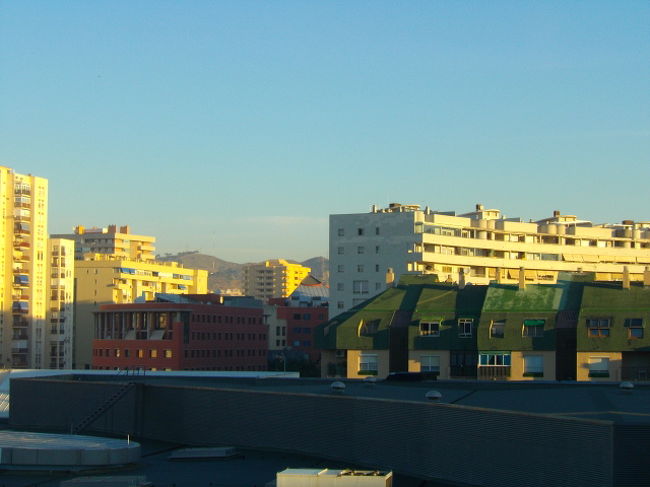 翌日、マラガのホテルの窓から<br />朝日が市内の建物を照らします