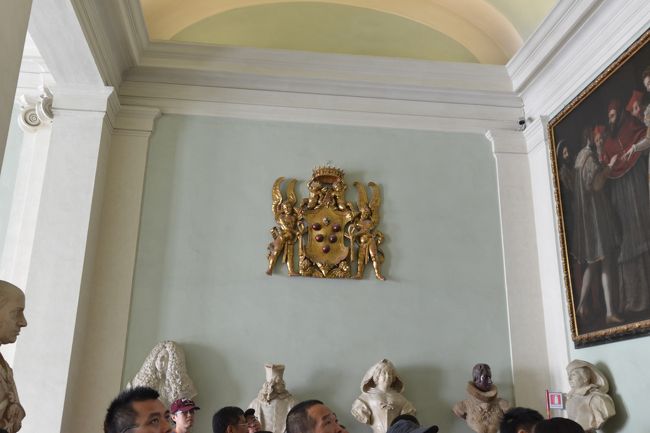 さあ、ウフィッツェ美術館に入場です。<br /><br />美術館入り口付近は来館者の長蛇の列。<br />しかし、我々は予約しておいたので、すんなり入場できました。<br /><br />美術館に入ると最初にメディチ家の紋章が目に入ります。<br /><br />赤い球は、丸薬を表しているとの事です。