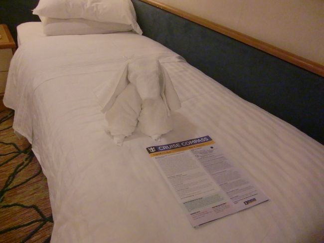 3〜4杯シャンパンをいただいた後、一旦部屋に戻りました。翌日のイベントやお知らせが書かれたクルーズコンパス（船内新聞）とタオルのワンちゃんが待っていました。