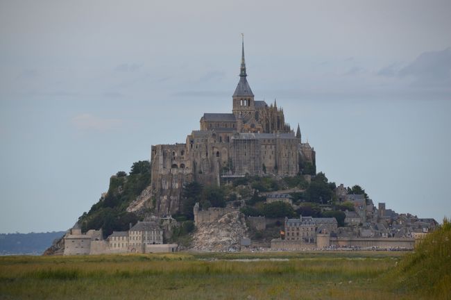 翌日、モンサンミッシェルへ。ツアーは日本で申し込んでおいた”みゅう”のツアー。デラックスバスでゆったり（プレミアム）、というふれこみで二人で５６０００円。バスの中も一応ネットが使える、なんとか。集合場所はギャラリーラファイエット本館ショセダンタン角玄関口で、すぐ分った。<br />これは遠くからの景色。