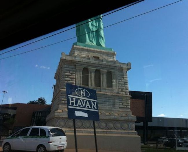 クイアバ到着！<br /><br />クイアバでは、この日のホテル、その後エコツアーの手配を現地の代理店さんにお願いしていたので<br />空港にはお迎えが来ていました。<br />お迎えのドライバーさんとはすぐに合流でき<br />そのままそこの代理店のオフィスへと向かい<br />30%のデポジットを送金したまま未払いだった残金の支払いに行きました。<br />本当はすっきり全額を支払ってから出かけたかったのに<br />Ｗ杯開催とFIFAさんのおかげで<br />送迎などの料金がギリギリまで確定できなかったとかなんとかで決済できず<br />当日、オフィスに連れて来られるまで<br />ちゃんとした料金もよくわからない状態。。。<br />てきとーすぎる。さすがブラジル人。<br /><br />エコツアーはこれまで何回か行きましたが<br />一般的に料金が高いことに加え(自然保護への貢献)<br />今回は、宿泊施設や交通機関などもＷ杯便乗値上げで高騰していた為、<br />治安の悪いブラジルで持ち歩く現金としては結構な額でした(~_~;)<br /><br />そんなわけで、これまでずっと大切に大切に分散して持ち歩いていたのですが<br />ここでやっと支払うことが出来、<br />肩の荷が下りた思いです＾＾;<br /><br /><br />画像は、どう見ても自由の女神さま。<br />車に乗っていたら突然現れました。<br />クイアバにもいらっしゃるなんて知らなかったです。<br />全体像を撮れなかったのが残念！<br /><br />