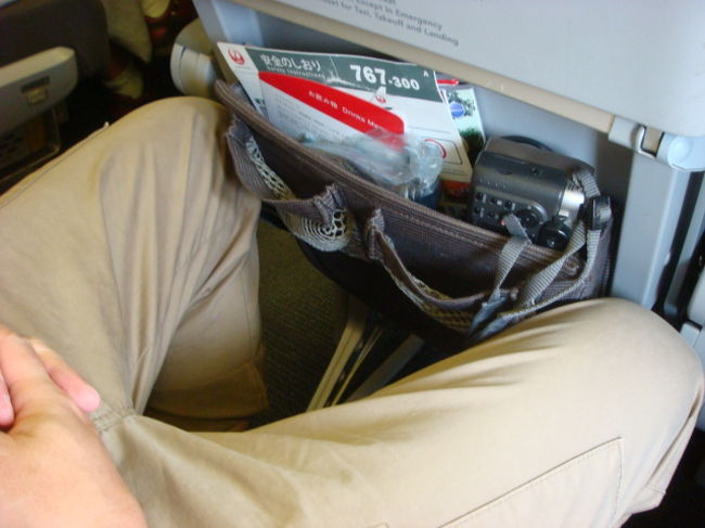 身長１８０センチの相方の足元はこんな感じ。今回は自己手配で座席ができたので、２２列をＡ・Ｂ確保。背中側がトイレになりますが、人が座っていないのでリクライニングシートを思いっきり下げることができました、本当に楽々のフライトでした。