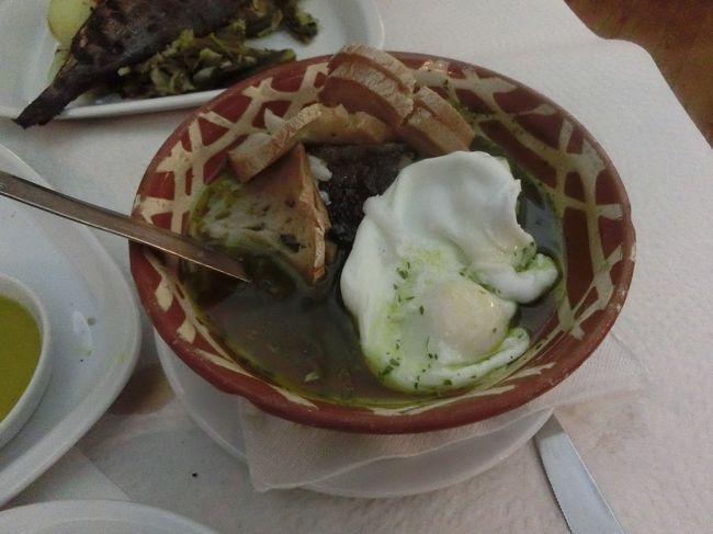 白身魚のぶつ切りとフランスパンとポーチドエッグをオリーブオイルで煮たもの。<br />汁は100%オリーブオイルです。<br /><br />実は、本当は「豚とアサリの煮た感じ」のが食べたくて、メニューを指差しながらポルトガル語の料理名を言ったのですが、メニュー名は発音が悪くて伝わらず、指は指したとこがビミョーにずれてて、豚アサリの下に書いてあった料理が来たみたい。<br /><br />でも旨かったよ♪魚は何だろ？鱸かなぁ。