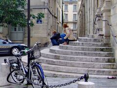 出ました！　ラベ・バセ広場！　Place de l'Abbe-Basset

またまた映画 『ミッドナイト・イン・パリ Midnight in Paris （仏：ミニュイ・ア・パリ Minuit a Paris）』 の登場です。　ここは、映画の中で、とても印象的なシーンが撮られていた場所でした。　主人公ギルが彼の憧れの1920年へタイムスリップさせてくれるクラシックな車（プジョー）があらわれたところです。

ギルは、今、私が通ってきた狭い道、　サン・テティエンヌ・デュ・モン通り　を歩き、この　小さな三角形の広場　に迷い込みました。　広場の　階段　で物思いに耽っていると、夜中０時の教会の鐘が鳴り、 ”車” があらわれました。　そして、その ”車” が 彼の憧れの世界 へ誘うのです。