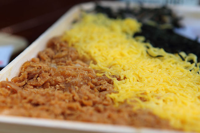 ちょうどお午なので折尾で買ったかしわめしを食べましょう。ちなみに「かしわ」とはニワトリのことです。手前の茶色いのがトリのそぼろ、真ん中が錦糸卵、向こうの黒いのが海苔という三色弁当です。