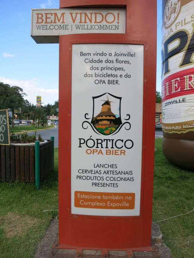 近くに看板がありました。<br />--------------------------<br />ジョインヴィレへ、ようこそ<br />花の街<br />王子達の街<br />自転車の街<br />そして、オッパービールの街<br />--------------------------<br />と書いてあります。<br /><br />ブラジルの都市で花の街と称している所は多いです。<br />第二次大戦前に、入植者の家の庭先に花を植える運動のようなものがあり、この名前がついたそうです。<br /><br />王子達の街は、ジョインヴィレという名前から来ています。ブラジルの皇女フランシスカがフランス王の三男、ジョアンヴィル公フランソワ・ドルレアンと結婚したため、1851年に記念してジョインヴィレという名前になったそうです。<br />ちなみに、Joinvilleでホテルを検索すると、フランスのホテルがヒットします。<br /><br />自転車の街は、50年ほど前にジョインヴィレで走っている自転車の数が凄かったので、この名前がつきました。今は殆ど見ません。<br /><br />最後のオッパービールの街というのは宣伝ですが、代わりに「ダンスの街（Cidade da Dança）」という言葉もあります。<br />