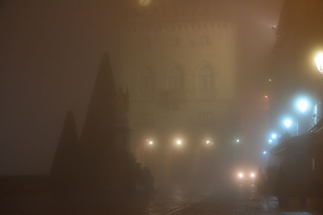 リベルタ広場。<br /><br />少し開けている事もあり、政庁の光も少ない。<br /><br />それ故、光の反射も少なく少し薄暗いイメージ。<br />向こうから車が走って来てますね。