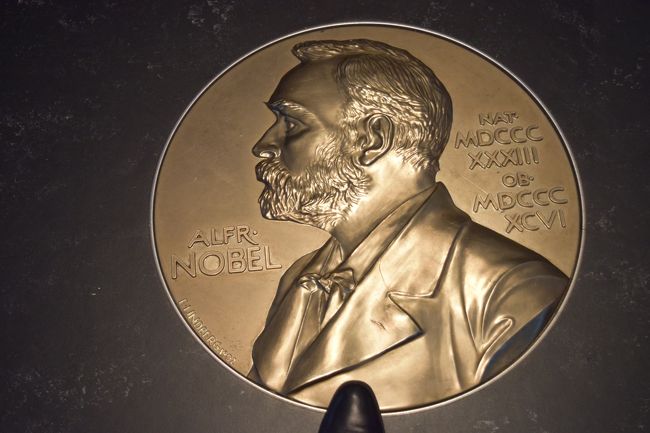 床にノーベルの金色の肖像が、埋め込まれています<br /><br />大きさがわかりやすいように、わざとブーツの足先を写してみました。