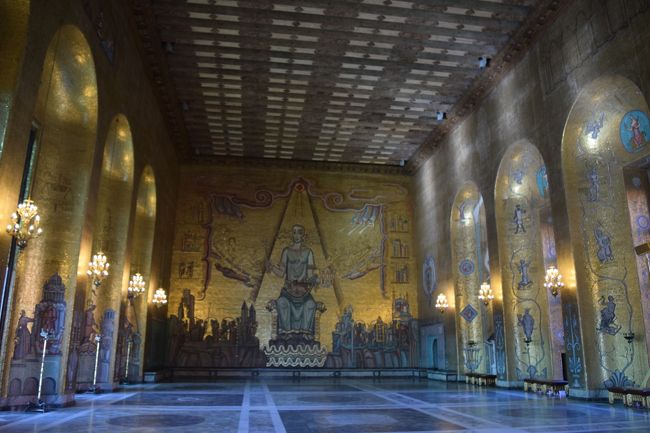 次のお部屋は。。。<br />"黄金の間"です。この黄金の間は、エイナル・フォルセッツ氏の創作で約1,800万枚もの金箔が使われたモザイク画が、壁面いっぱいに描かれています。この部屋は1900万枚の金箔のモザイクで飾られていて、まさに、金ぴか。ガラスの間に溶かし入れた金箔は、永遠に輝きが失われることはないとのこと。<br /><br />ここでは、ノーベル賞祝賀会のダンスパーティーが行われるらしいです。<br /><br />