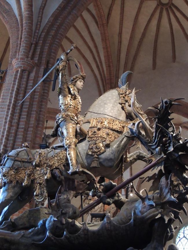 高さ３．６ｍの「セント・ジョージと龍」の木彫。　<br />兵士と十字軍の守り神として戦いへの勇気を与えるとされるセント・ジョージ（聖ジョージ）が馬上から剣を振りかざし悪龍を退治するこの像は１４８９年にドイツ人によって作られたらしい。　また、その台座にはリーメンシュナイダー風のレリーフが刻まれている。