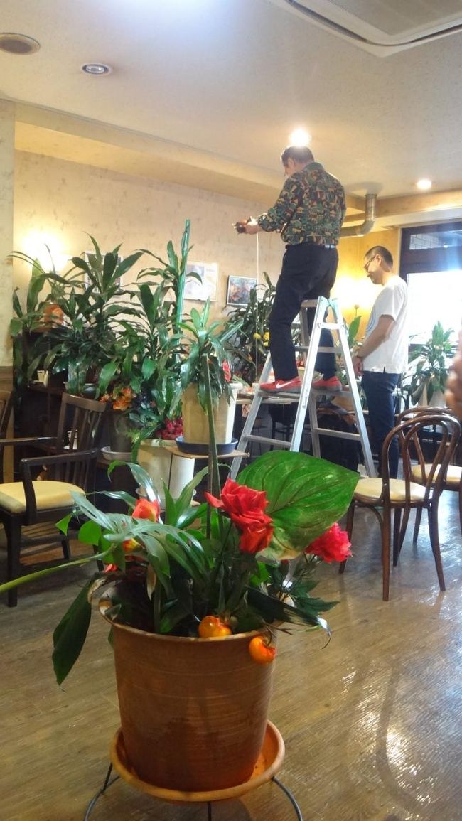 マスターが脚立に立って高いところから２つのコーヒーポットで注ぎます。