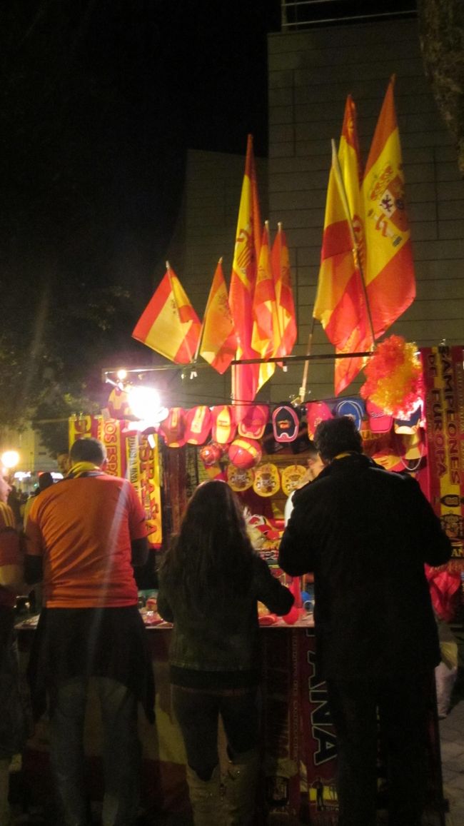 マドリードの地下鉄、黄緑色の5番線に乗ってpiramides駅まで。いつもはすいてる地下鉄ですが代表戦とあって東京の満員電車並みにパンパンでした。<br />露店が何個かあり、スペイン代表のマフラーやユニフォームなどが売ってました。オフィシャルグッズではないためエンブレムはついてなかったです。