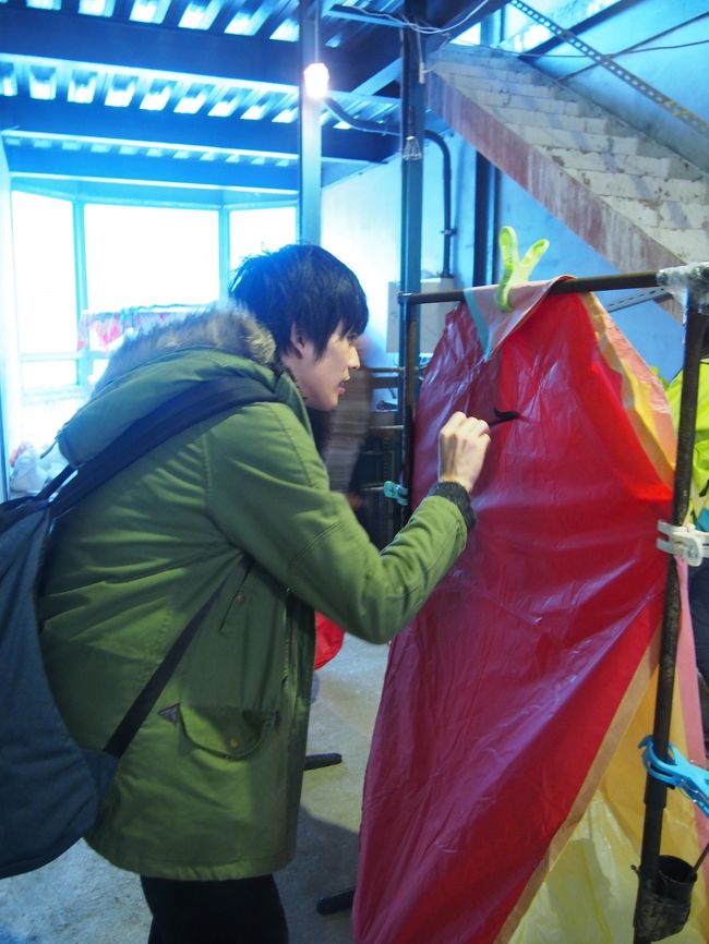 でも結構大きなランタン。<br /><br />どこで文字を書くのだろう、と思っていたら、<br />脇にランタンを書くためのスペースがありました。<br /><br />洗濯物を吊るすようなところに、ランタンを吊るします。<br />棒に墨が入った入れ物が括りつけられていて、そこに筆が用意されていました。<br /><br />ひさびさのお習字。<br /><br />結構おおきなランタン。<br />何を書こうか悩みます(｀ω´*)<br /><br />周りは日本人も結構いました！<br />