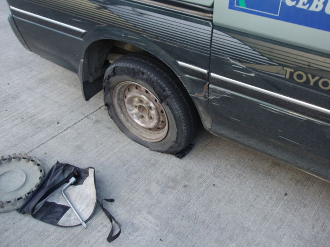 翌朝車でセブ島の北端に向かいます。<br />途中で車がパンクしちゃって、修理中。