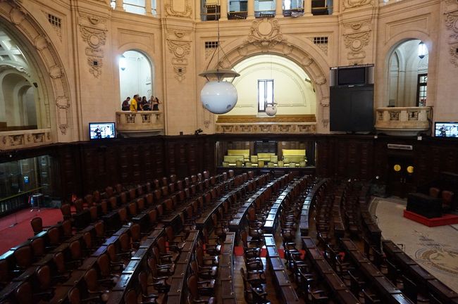 現在も使われている会議場。立派な椅子が４００以上並んでいますが、議員数はその１/３で、全部は使われていません。議員の言動を見るためにTVカメラが備えられ、議会があるときは、画像は一般向けに配信されています。なので、議員は行儀の悪いことはできません(ガイドの話)。<br />この後、会議場を取り巻く回廊に展示されている写真やパネルに従い、ブラジル民主主義の歴史等の説明を受けます。