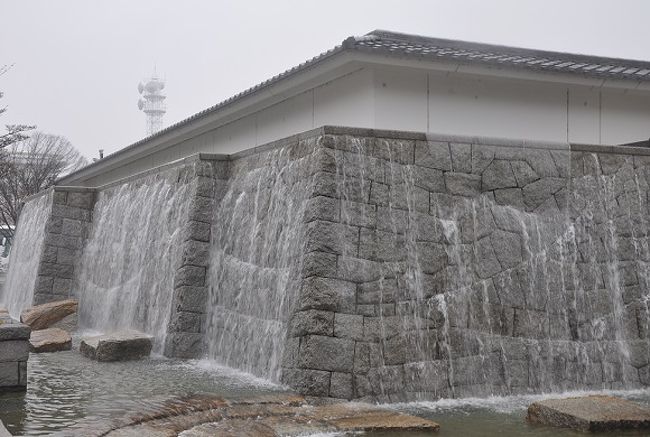 能楽堂の石塀の水ら流れていて