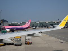 香港国際空港へ到着。お隣の派手な機体はタイのサイアム・エア。北サテライトのターミナルなのでこの後バスで移動。