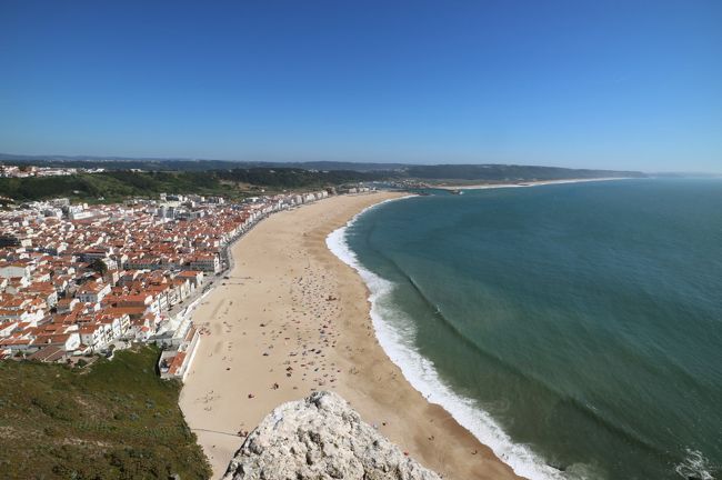 町と海をバランスよく配置、砂浜には日光浴する人が沢山います。