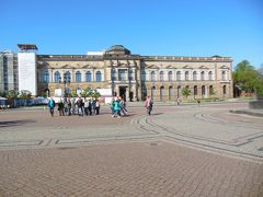 テアーター広場はドレスデン観光の中心地の一つ。
ルネサンス様式やバロック様式の建物が広場を取り囲んでいます。

この建物は18世紀初め、ザクセン選帝侯とポーランド・リトアニア共和国の国王とを兼ねたフリードリヒ・アウグスト１世（ポーランド王としてはアウグスト２世）が建てたツヴィンガー宮殿です。
第二次世界大戦末期、米英同盟軍によるドレスデン大空襲で崩壊しましたが、その後修復され、1992年によみがえりました。
内部は陶磁器博物館と絵画館になっていて、私たちは後で絵画館を見に行きます。

建築を命じたフリードリヒ・アウグスト１世はドレスデンの歴史上重要な人物です。
怪力の持ち主であったことから「アウグスト強王」などと呼ばれます。