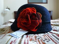 Estonian Houseと言う中心部に近い割と大きめの手工芸品中心のお土産物屋さんで。
木工品からニット製品から、高い物から安い物まで一通りあって、珍しく営業時間が20時くらいまでと長かったので、観光客には便利だと思います。
他のお店が軒並み閉まっている中やっていたので思わず入ってしまいました。
他のお店でもこういうお帽子は見かけていてかわいいな〜と思いつつ、私は帽子はフィット感が少しでも悪いとかぶらなくなってしまうので遠慮していたのですが、かぶってみたら抜群のフィット感だったので買ってしまいました。地のフェルトが色鮮やかなものも心惹かれましたが、後でかぶる勇気を失う可能性があったので控えめなものにしました。39ユーロ。
レジでご婦人の写真を見せられて、この帽子は彼女が作ってるのよ！と教えてくれました。