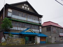 増毛駅前の木造3階建ての「富田屋」。旅館は廃業し内部を見ることはできません。右の赤い屋根の建物は多田商店。映画駅STATIONで風待食堂として撮影が行われた場所です。現在は観光案内所となっています（表紙写真は正面から撮影したもの）。