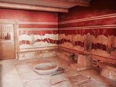 クノッソス神殿へは、港の近くのバスターミナルからブルーのバスに乗って約３０分。終点。往復で３E。

跡とは言え、３７００年前の宮殿が復元され保存されている。
ここは王座の間。
壁には架空の動物『グリフィン』が描かれている。