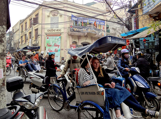 ホアンキエム湖の北、旧市街を走る観光客を乗せたシクロ。