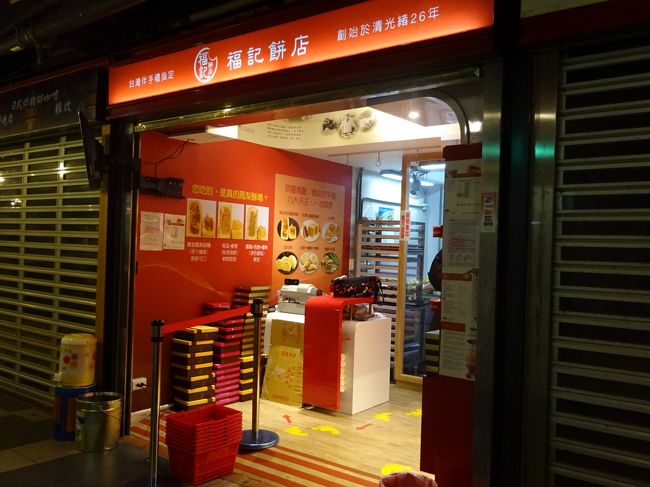 夏に来たときは、早朝は閉まっていたこのお店。こんな早朝に開店しているので覗いてみました。看板は「福記餅店」ですが、商品は華山市場近くに店舗を構えるおへそ餅で有名な「満福堂餅行」のものです。中の作業場で看板商品の「おへそ餅」を焼いていました。