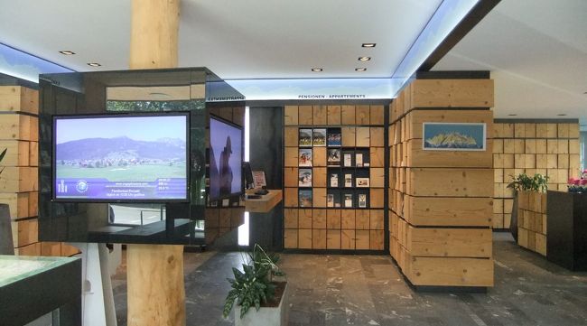 ホテルで少し落ち着いた後、Lermoosの村を少し散策することにしました。<br />まずはツーリスト・インフォメーションに。<br />場所はバス停Lermoos Unterdortのすぐ近くです。<br />ちなみに教会はそこから徒歩7,8分です。<br /><br />写真はツーリスト・インフォ内です。木が使われていてなかなか素敵なデザインです。<br />大まかなハイキングコースやバスの時刻表も記載されたTiroler Zugspitz Arenaの地図、Lermoosの地図、イベントのスケジュールのチラシ等頂きました。<br />ちなみに、時間外でも通路に資料が置かれているので入手可能です。