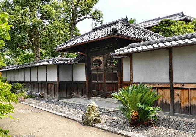 高石垣の手前を左方向に進んで右折すると、こうした庭園北口までのアプローチが待ち受けています。単なるアプローチなのですが、ここにもいろいろな仕掛けがあります。<br />通路右手の高石垣の奥にある建物群に通じる門は、簡素ながら侘び寂びを湛えています。扉の透かしは特に凝った意匠です。<br />通路の左側には竹垣が伸び、右手には白い源氏塀が訪問者を北口へと誘います。塀軒下には古瓦が並べられ、石が配された趣のあるアプローチです。