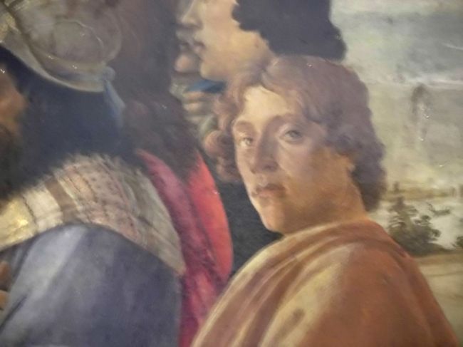 そしてボティッチェリの自画像もしっかり描かれています。<br /><br />ところでボティッチェリの本名はサンドロ・ディ・マリアーノ・フィリペーピと言うそうです。<br />ボティッチェリはあだ名で「小さな樽」と言う意味です。<br />これは彼のお兄さんが太っていたので「大きな樽」。<br />その弟なので「小さな樽」と言う渾名だったみたいです。<br /><br />酷い話ですが、<br />ヴェロネーゼは「ヴェローナ人」<br />ペルジーノは「ペルージャ人」<br />ティントレットは「染物屋の息子」<br />ギルランダイオは「花飾り」<br />レオナルド・ダ・ヴィンチは「ヴィンチ村のレオナルド」<br /><br />ティッツィアーノ、ラファエロ、ミケランジェロも全員苗字ではなく名前呼びされています。<br /><br />当時まだ画家の地位が低かった証明でしょうか？