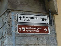 さて、前置きが非常に長くなりました。(；´･ω･｀)ゞ

いよいよ、ここからはわき目も振らずにリュブリャーナ城へと向かいます。

街角のあちこちに、お城への道を示す標識も出ています。
これだと、フニクラ（ケーブルカー）駅へは直進。
歩いて行くなら右折。

いつものSUR SHANGHAIなら右折にしたでしょうが、今日はフニクラで楽チンしてみます。
