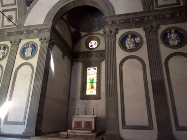 パッツィ家の礼拝堂。<br /><br />パッツィ家はパッツィの乱の時、こともあろうにロレンツォ豪華王をドゥオーモのミサの時に殺そうとした一族。<br />ロレンツォは辛くも凶刃から逃れましたが、弟のジュリアーノは殺されてしまいました。<br />しかもその裏には教皇のシクトゥス４世、その甥のジローラモ・リアーリオも絡んでいました。<br />ロレンツォの怒りは凄まじく、首謀者は全て死刑、パッツィの一族は全員フィレンツェ追放の刑に合っています。<br /><br />そのためかパッツィ家の礼拝堂はルッカ・デッラ・ロッビアのメダイヨンしかありません。<br />これは１４４０年頃の作品。<br />いくらなんでもこんな簡素なわけはないので、多分、パッツィの乱の後、全ての壁画を剥ぎ取られるてしまったのでしょう。