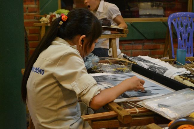 途中、トイレ休憩で立ち寄ったお土産屋さんにて。<br />女性たちが一生懸命糸で絵を作っていました。