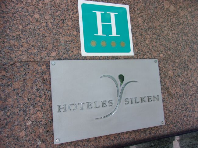 玄関をくぐるときホテルのランクを示す<br />標識を見た。<br /><br />4つ星ホテルだ。「お値段が高そう！」<br /><br />フロントの女性に<br />「予約はしていないのですが宿泊できますか？」と<br />尋ねる。<br /><br />フロントの女性がきれいな英語で<br />「できますとも。」<br />と応える。<br /><br />「一泊いくらですか？」<br />と尋ねると、<br /><br />彼女は<br />「○○ユーロです。」と言う。<br /><br />私は一瞬、その金額が理解できない。<br /><br />彼女は私が英語が分からないのだろうと思ったのか<br />メモ用紙を取り出して金額をゆっくり書いてくれた。<br /><br />一泊何と160ユーロだ！<br /><br />私は即答できず息をのみこんだ。<br /><br />公的アルベルゲ宿泊の10日分以上だ。<br /><br />※スペインの公的アルベルゲは１泊１２ユーロ前後<br />　で泊まれる。<br />　夕食は巡礼者料金で１０ユーロ。<br />　ワイン１本付き<br />　前菜、主菜、デザート付の合計で<br />　この値段である。<br /><br />「朝食込みですか？」<br />と聞くと。<br /><br />「このお値段には朝食は含まれておりません。」<br />とおすまし顔で事務的な答えが帰って来る。<br /><br />フロントの中にいる男性スタッフがチラリと<br />こちらを見る。<br /><br />わたしは振り返ってホテルの外を見る。<br /><br />外はまだ土砂降りの雨だ。<br /><br />私は清水の舞台から飛び降りた気持ちで<br />「一泊だけお願いします。」と<br />応えるのが精いっぱいであった。<br />