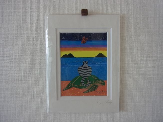 実家に1枚、姉宅に1枚、うちに1枚。こちらが私んちにやってきた作品です。猫ちゃんがホヌの背中に乗ってハワイの海を眺めています。リビングに飾りました。とっても気に入っているお土産です。