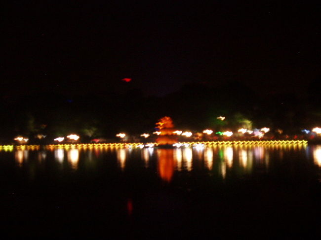 夜のホアンキエム湖へ。ホテルから近いのに、実はこの夜に初めて近くまで来ました。というのは、ホアンキエム湖の前の大通りが往来が激しく怖くて渡れなかったからです。3日目にしてやっと渡り方（堂々と渡る。もしくは地元の人にくっついて渡る）を身に着け、湖の周りの遊歩道を散歩することができました。<br />地元の人々がダンスしたり、ベンチでくつろいだり、暑さがひいた夜の湖をのんびり楽しんでいました。