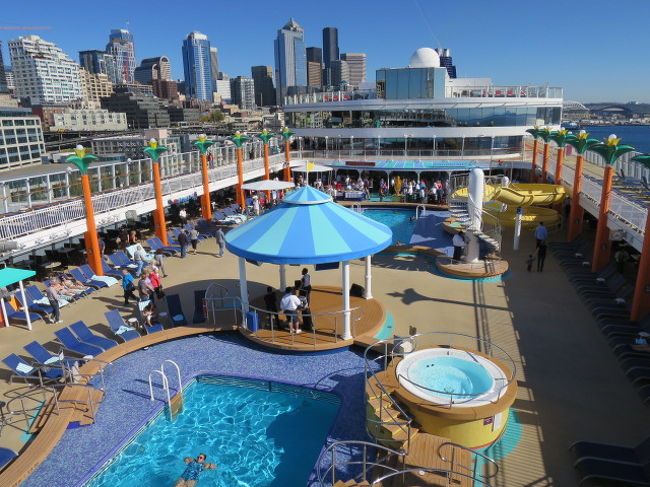 屋外に出て出航を待ちます。あと探索です。<br /><br /><br />１２階の広場です。<br />遠くにビル群が見えます。別世界です。<br />プールがあります。もう泳いでいる人がいました。<br />この日気温は２６℃くらい。少しプールに入るのは寒いかな？ってくらいでしたが外国の子供たちは滑り台のあるプールで大はしゃぎしてました。<br />私たちは水着を持っていったのですが、結局一度もプールもジャグジーも利用せず。。。(*_*)恥ずかしがってしまって残念。<br /><br />