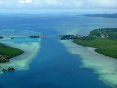 一旦、ロマン・トメトゥチェル国際空港（旧名：パラオ国際空港）の滑走路の端っこまで移動して飛び立った小型機。

最初にフワッ！と宙に浮いた時の足元がおぼつかない感じがスリリング。

すぐに、空港があるバベルダオブ島と一番賑やかなコロール島の間の水路を通過。
この画像だと右手がバベルダオブ島。

画像中程には、コロール・バベルダオブ橋（KBブリッジ）も見えています。
この橋については、遊覧飛行の終わりにもっと近い場所を通過したので、この旅行記の終わりに紹介します。

う〜ん、ちょっと雲が多いね。
雨季だから仕方ないけど、欲を言えば、もう少し晴れ間が出て欲しい。(-人-) 