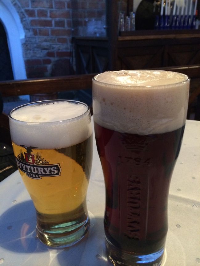 ホテルすぐそばにあったオープンエアなレストランで晩御飯を食べることに。<br /><br />無事の到着を祝って乾杯！<br />どちらもリトアニアビールです。<br />右の黒い方がなかなかお気に入り。