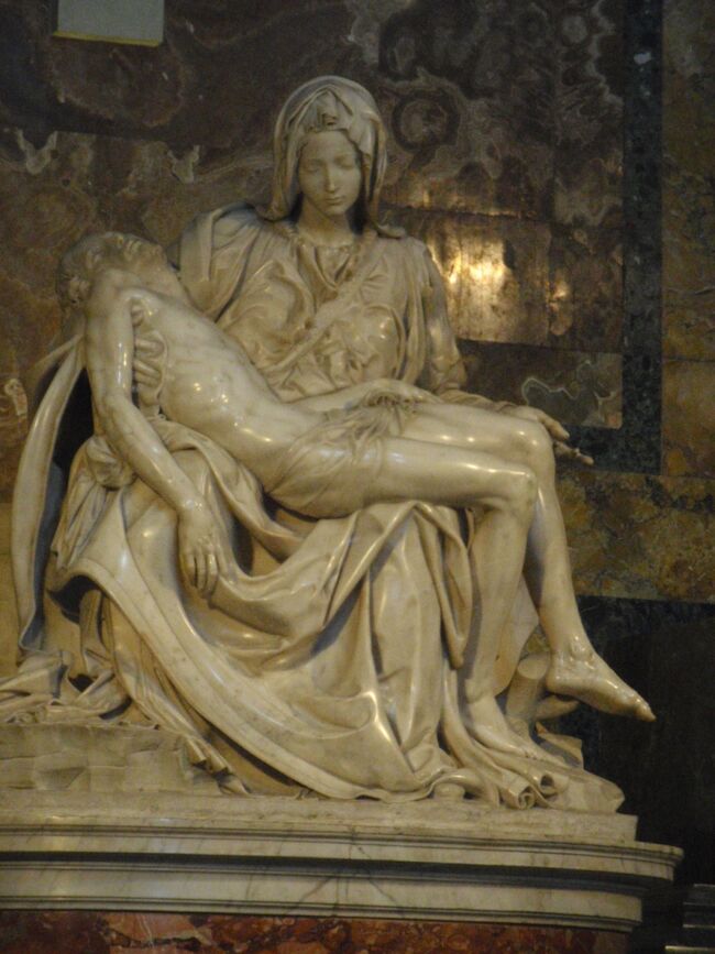 ミケランジェロ1498～1500年　「サン・ピエトロのピエタ像」。大理石、高さ174ｃｍ<br />＊ミケランジェロのサインが入った唯一の作品。23歳の時の傑作。若くして正に天才ぶりを発揮してる。<br />＊慈悲深いマリアの表情や抱き上げる指一本までも完璧。<br />＊何度か破壊され、鼻や指が欠落したマリア像でも、劣化は反って観る人の想像力で「欠落の美」を与える。<br />＊理想的な人体表現が追求され、これ以上望みえないほどの完成度と言われてる。<br />＊ミケランジェロはローマ滞在時、バッカス像と、このピエタの成功により名声を得て、芸術家としての地位を不動のものとするきっかけとなった。ミケランジェロが制作したピエタは、死せる息子キリストを抱える聖母マリアの悲しみに満ちた表情や筋肉や衣服の細密な描写など、それまでに彫刻されたピエタの表現を遥かに超えたものであった。<br />