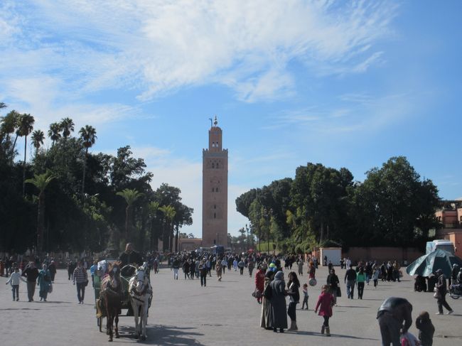 マラケシュのシンボル、クトゥビア・モスクのミナレットが見える。<br />馬車も走って来る。<br />