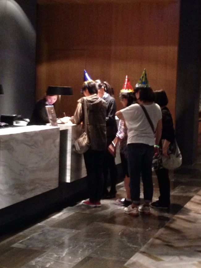 帰りにフロントでマッサージの予約。みんな、頭に三角帽子かぶってるの忘れてるね（笑）